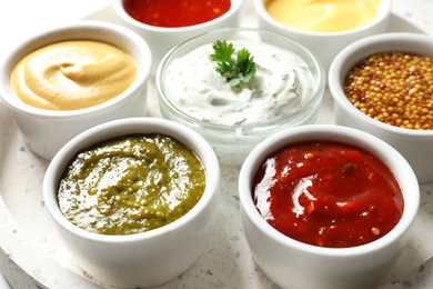 Photo of Set of different delicious sauces on tray, closeup