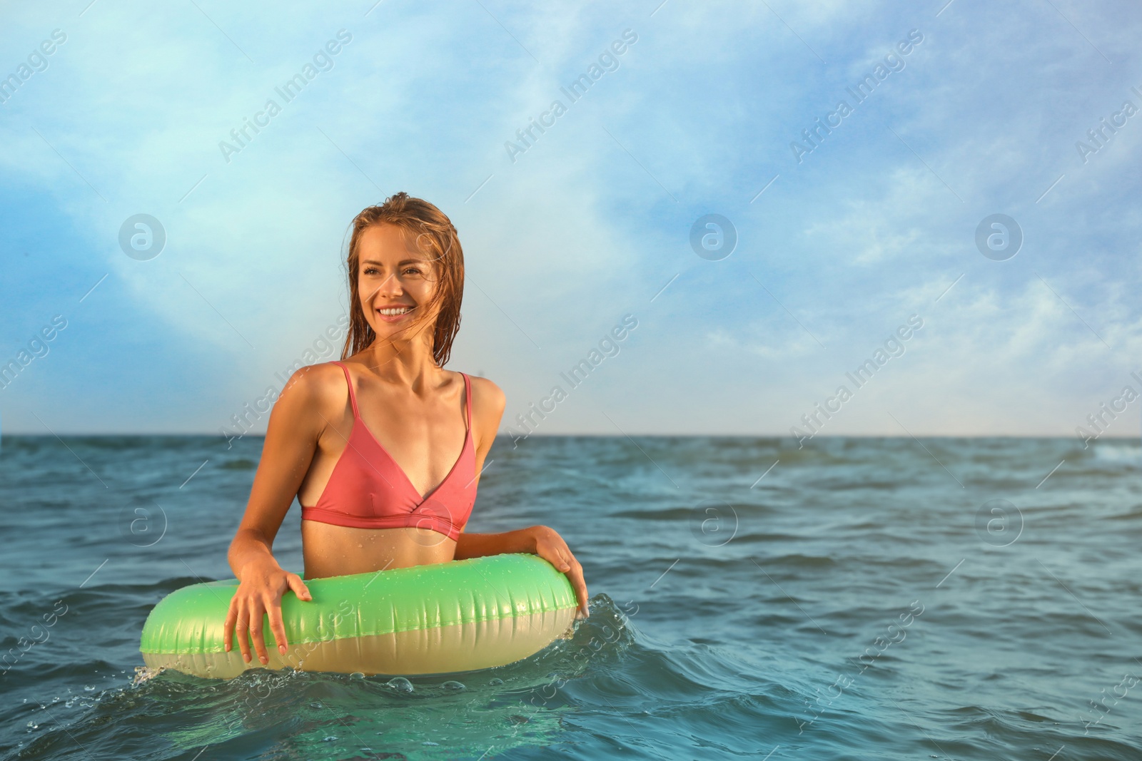 Photo of Beautiful woman with inflatable ring in sea, space for text