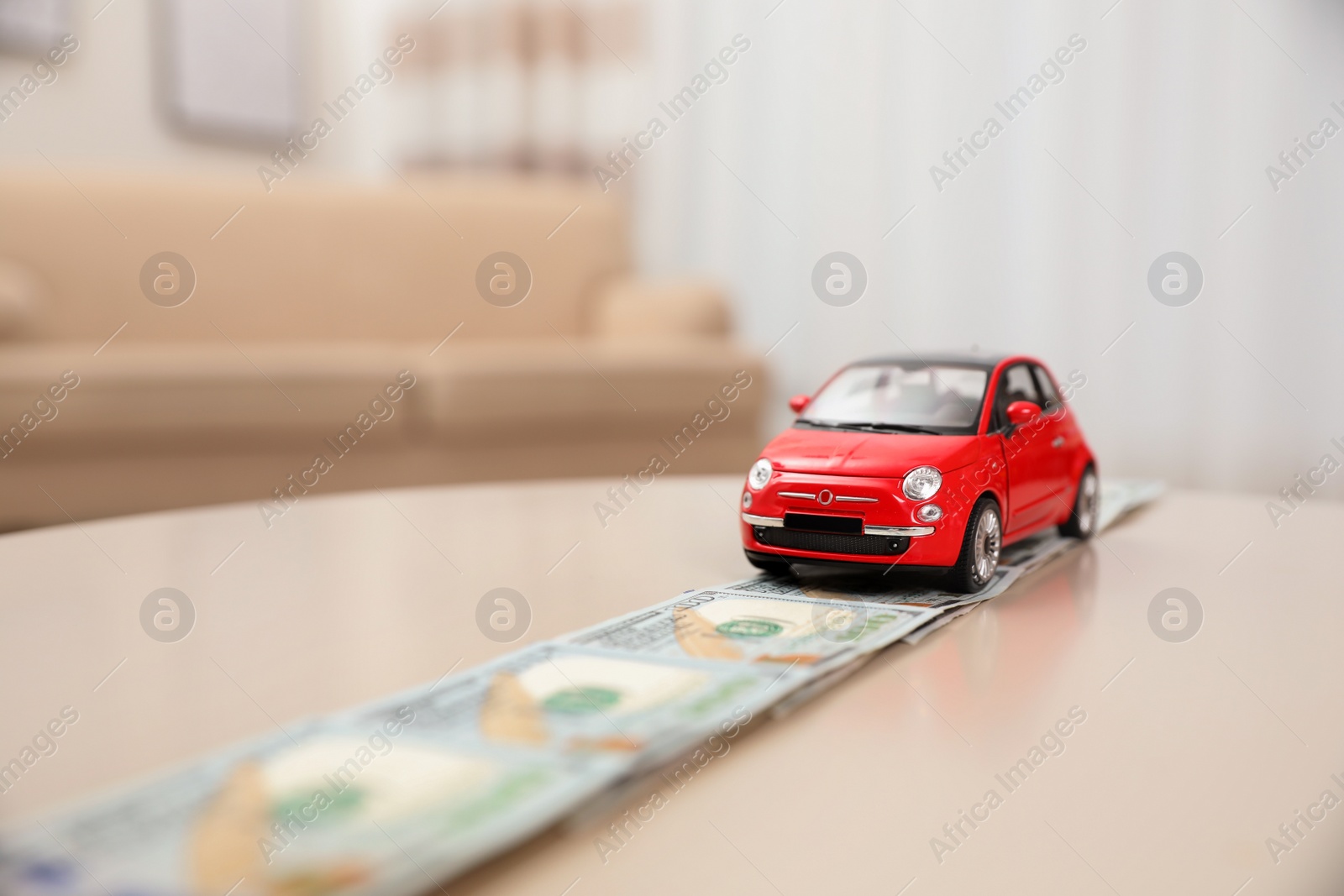 Photo of Miniature automobile model and money on table indoors, space for text. Car buying