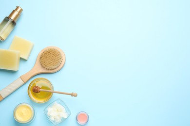 Flat lay composition with beeswax and cosmetic products on light blue background. Space for text