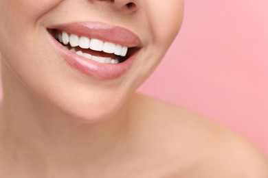 Photo of Woman with beautiful lips smiling on pink background, closeup
