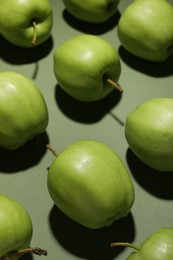 Photo of Many tasty fresh apples on green background