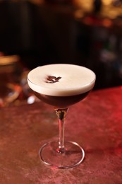 Photo of Glass of delicious Espresso Martini on bar counter. Alcoholic cocktail