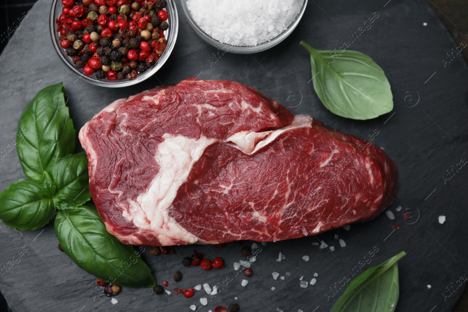 Photo of Flat lay composition with cut fresh beef meat on black table