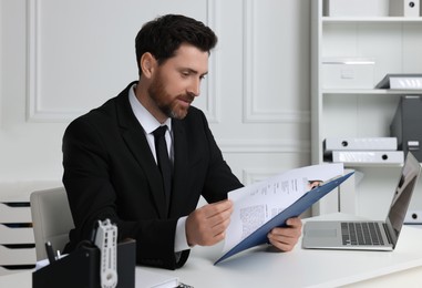Photo of Human resources manager reading applicant's resume in office