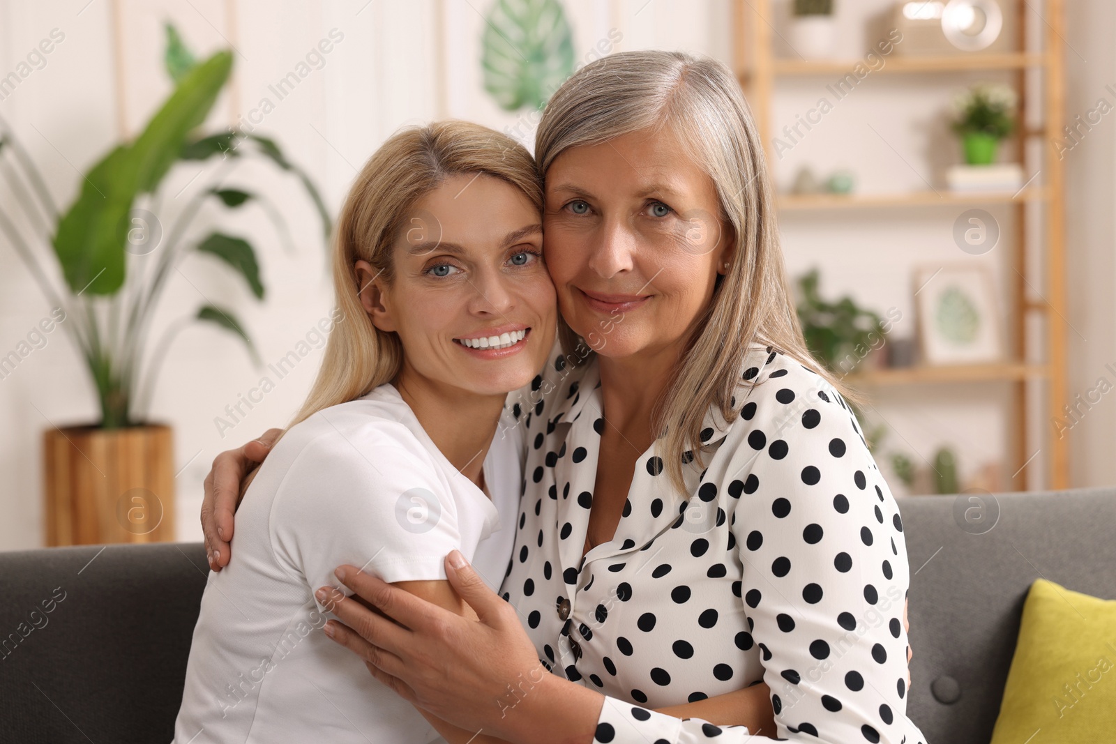 Photo of Happy mature mother and her daughter hugging at home