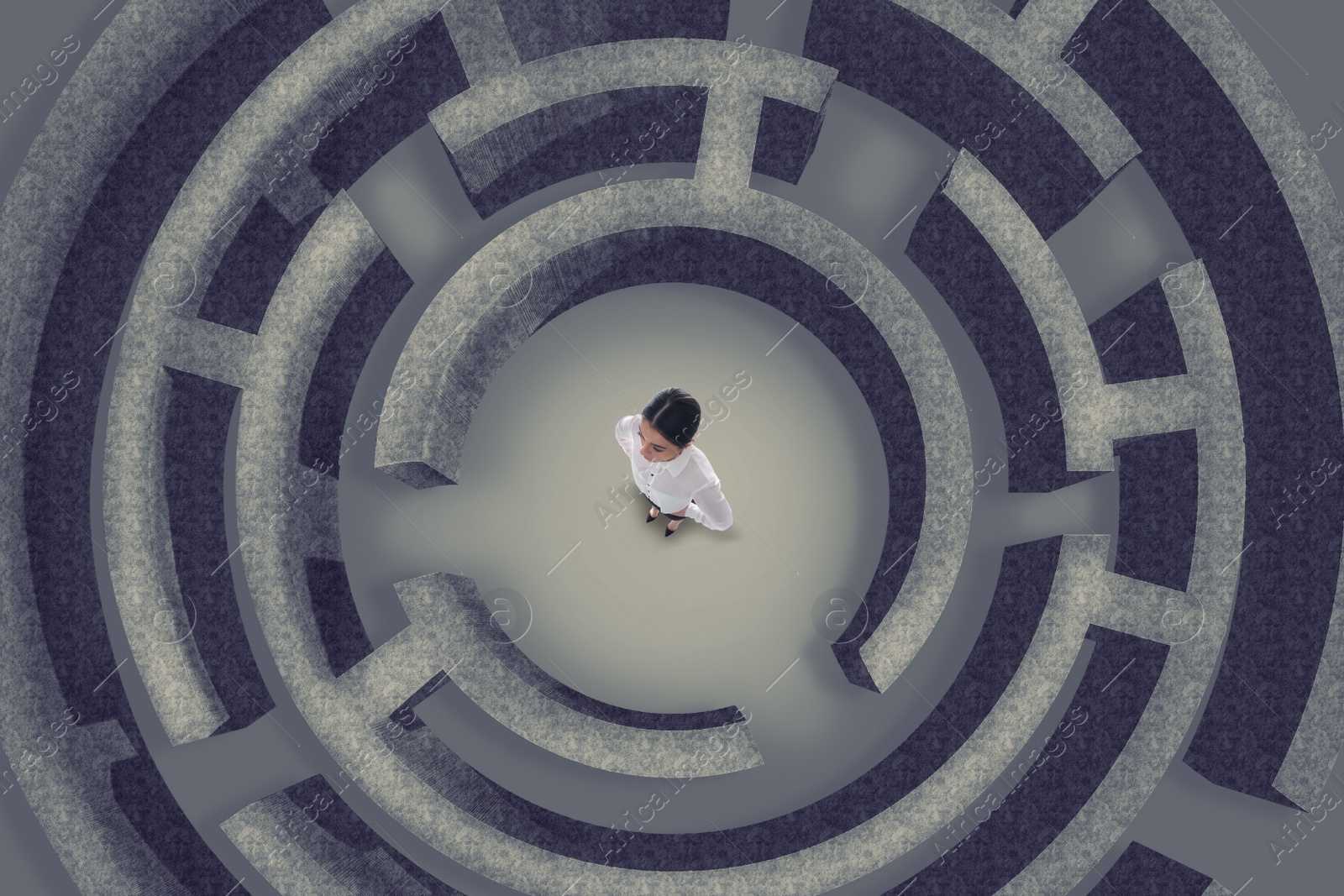 Image of Businesswoman trying to find way out of maze, above view