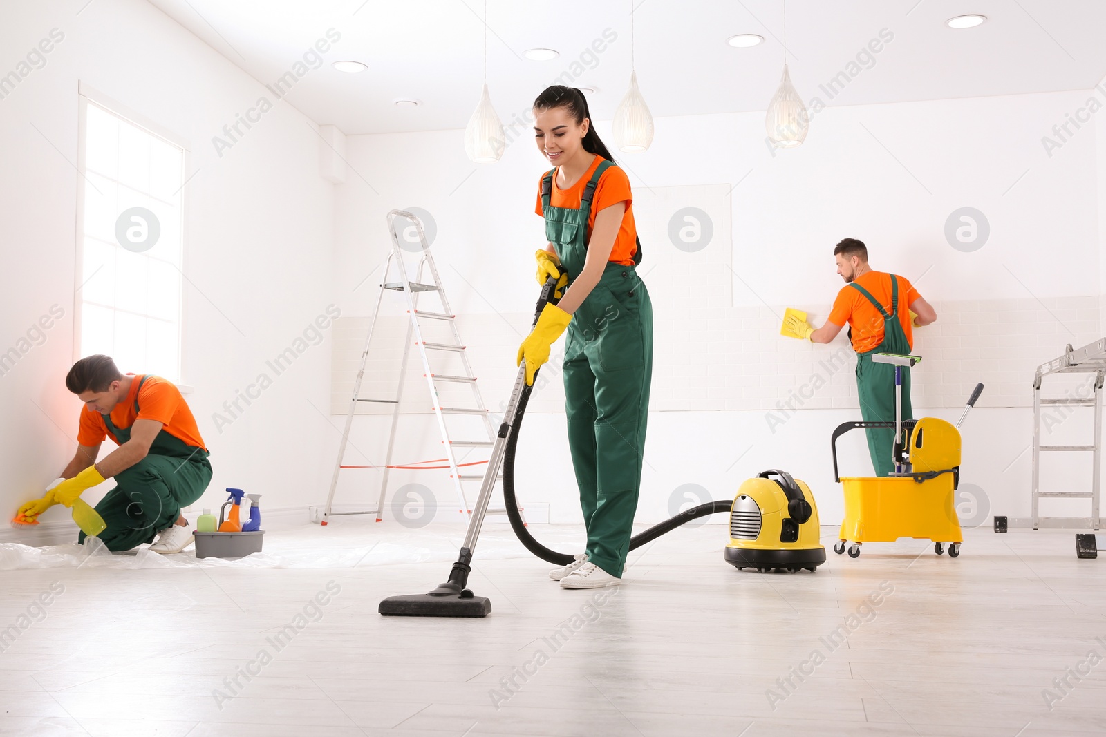 Photo of Team of professional janitors cleaning room after renovation