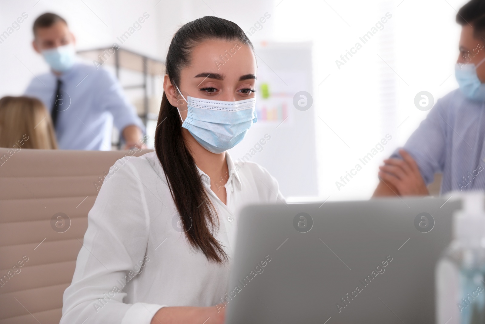 Photo of Female worker with mask in office. Protective measure during COVID-19 pandemic