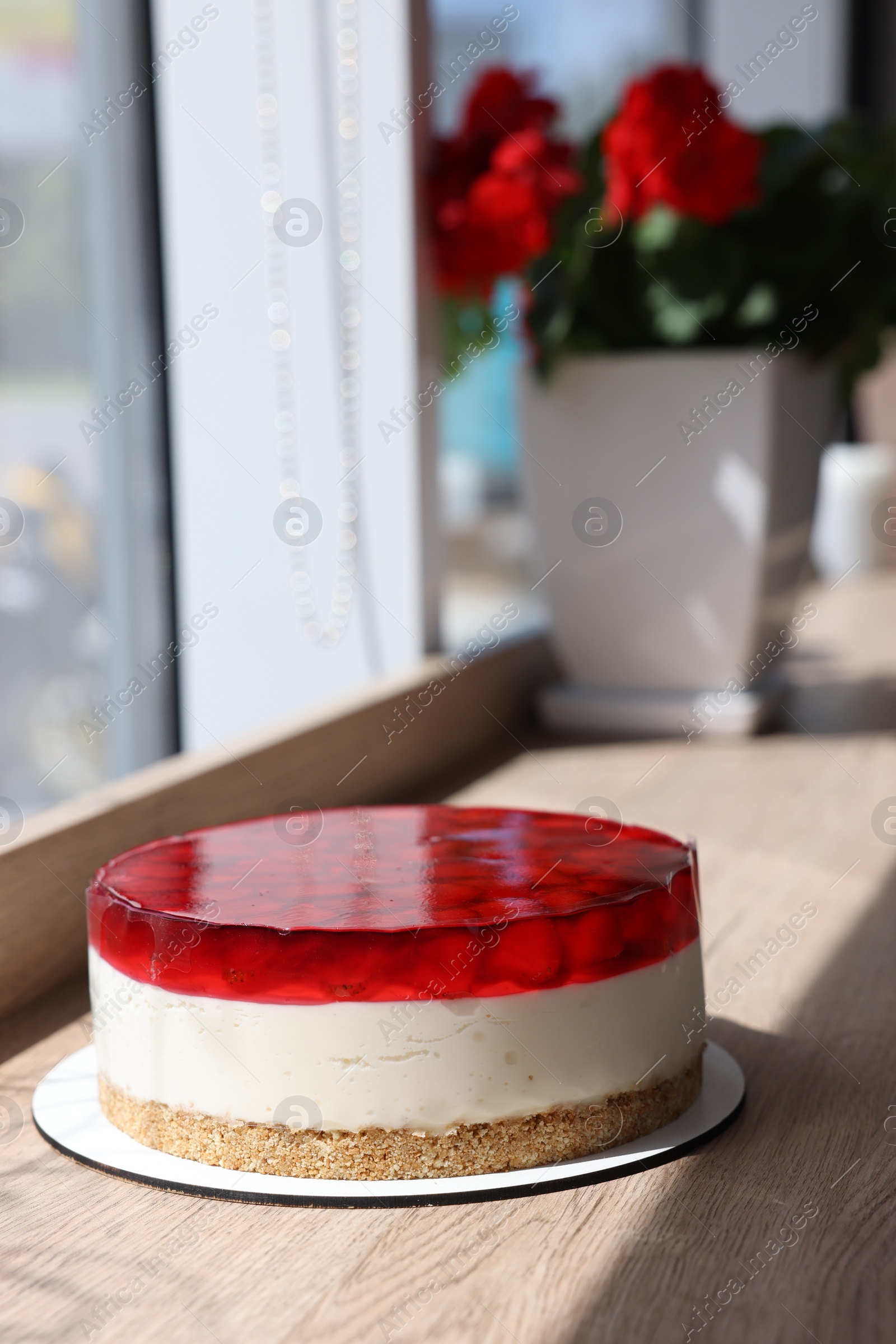 Photo of Delicious cheesecake with jelly and strawberries on wooden table. Space for text