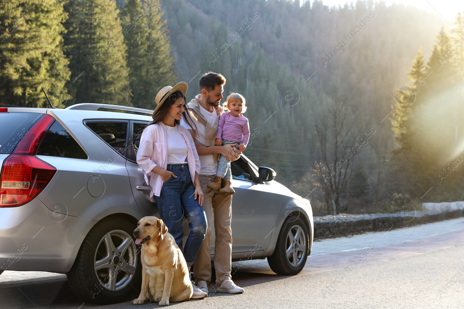 Photo of Parents, their daughter and dog near car outdoors, space for text. Family traveling with pet