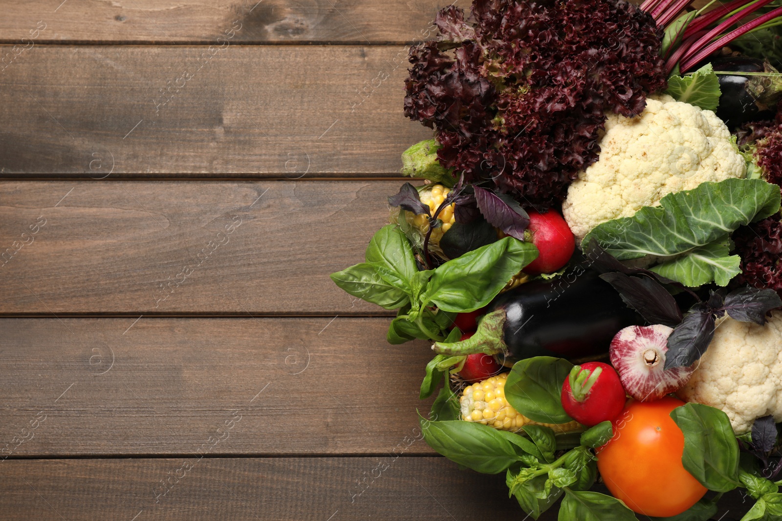 Photo of Many different vegetables on wooden table, flat lay. Space for text