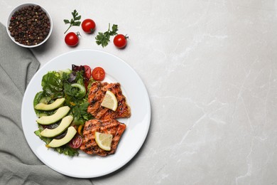 Photo of Tasty grilled salmon with avocado, lemon and tomatoes on light grey table, flat lay. Space for text