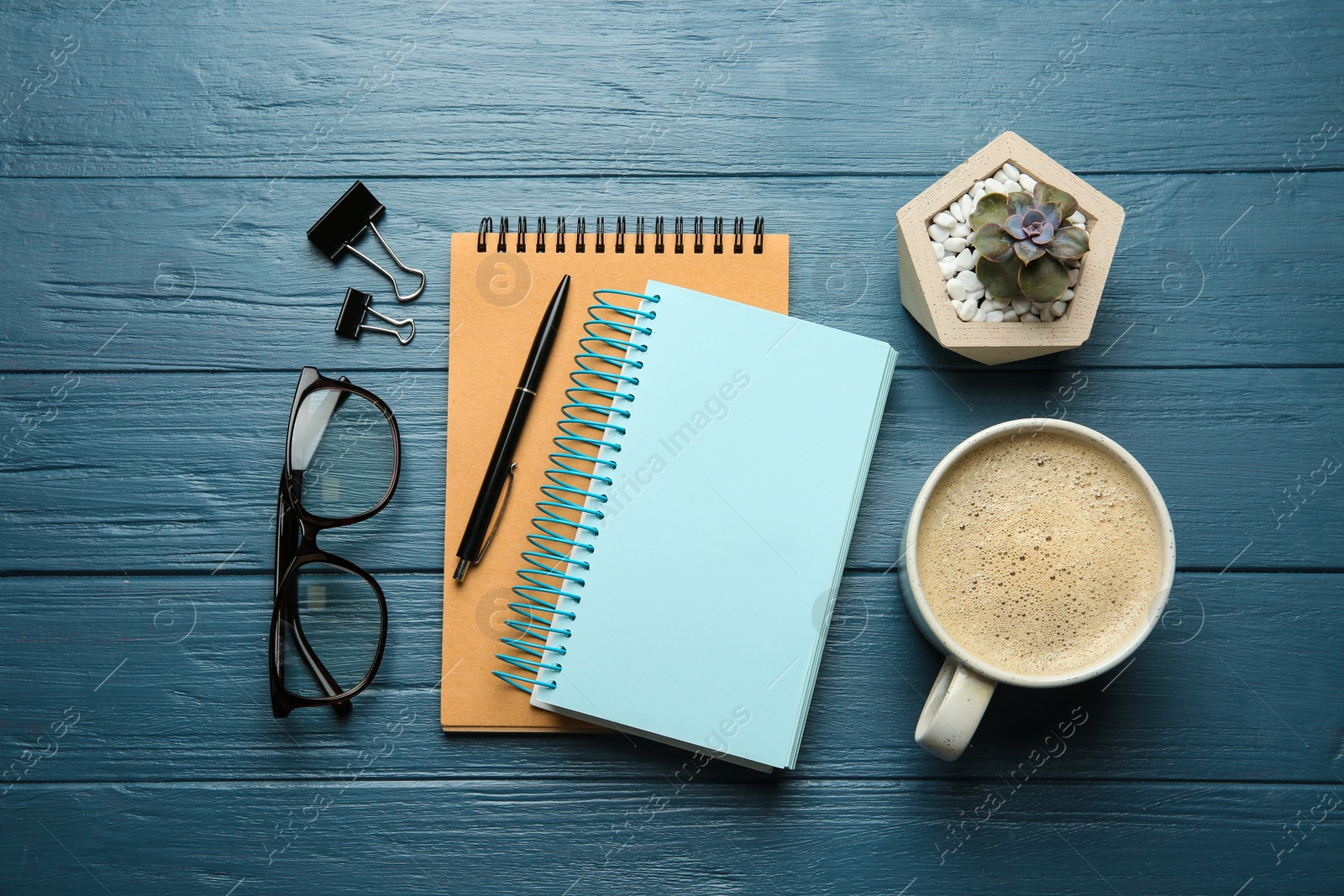 Photo of Flat lay composition with office stationery and cup of coffee on blue wooden table. Space for design