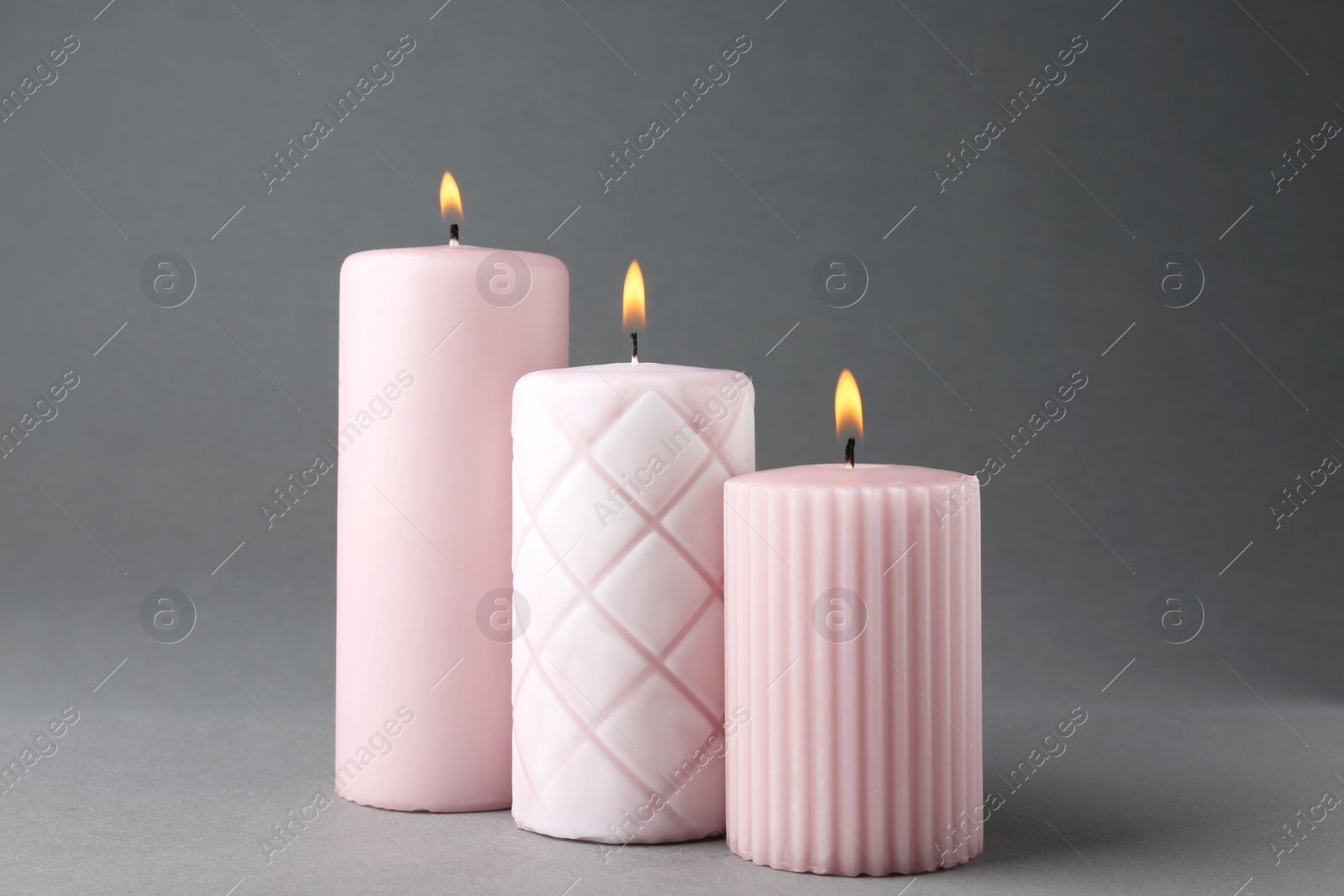 Photo of Burning candles on grey background. Interior elements
