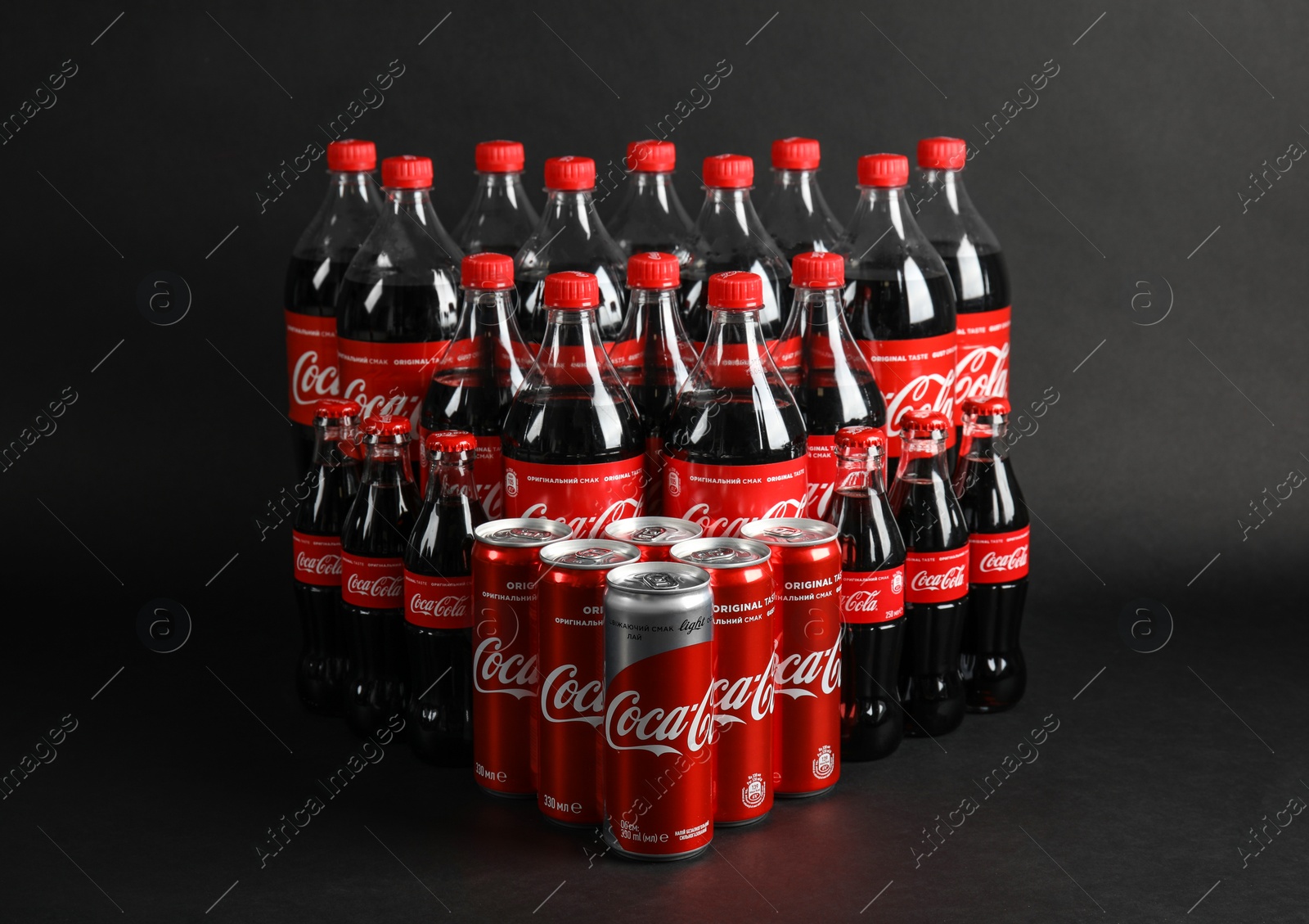 Photo of MYKOLAIV, UKRAINE - NOVEMBER 16, 2018: Bottles and cans with Coca-Cola on dark background