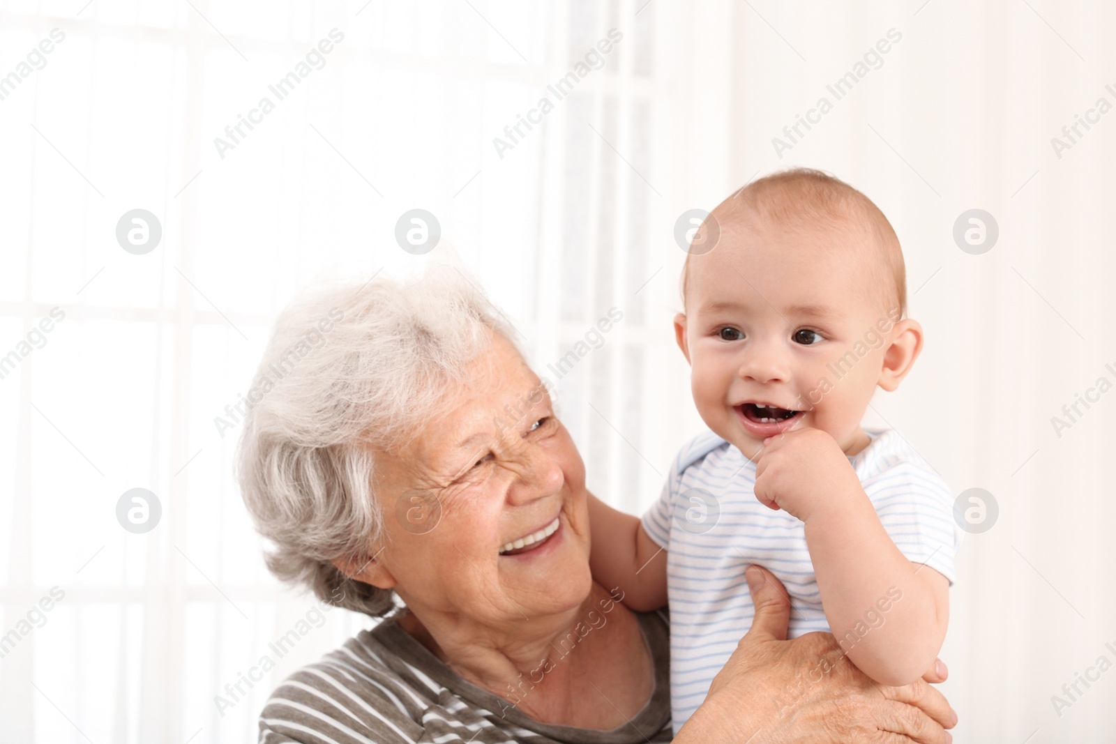 Photo of Happy grandmother with little baby at home