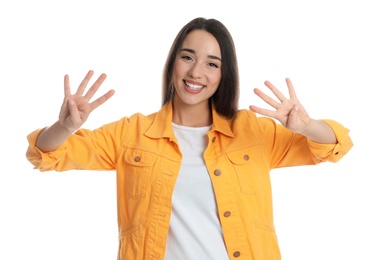 Woman in yellow jacket showing number eight with her hands on white background