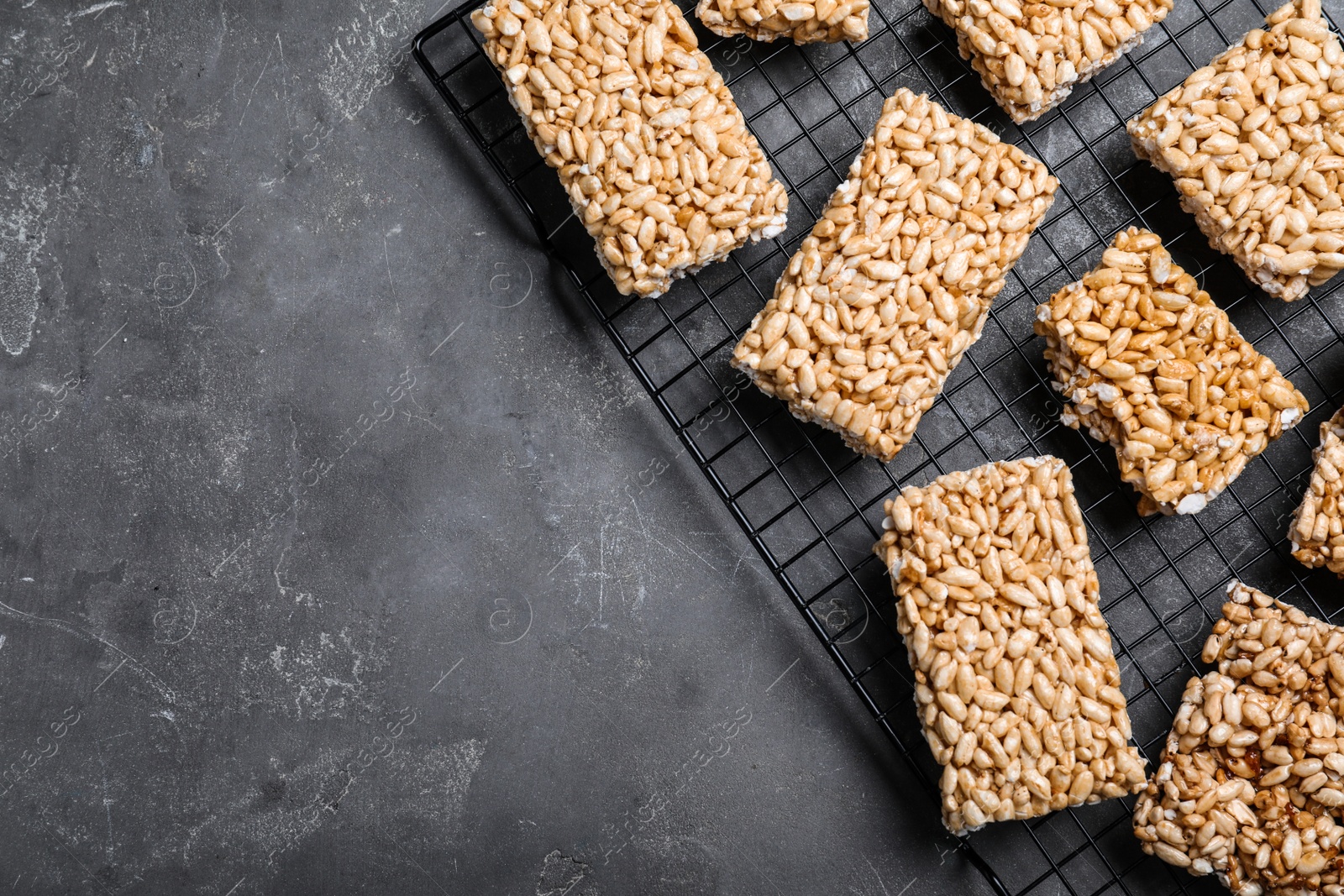 Photo of Delicious rice crispy treats on grey table, flat lay. Space for text