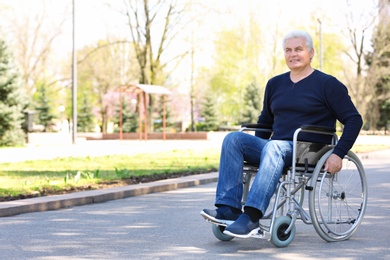 Photo of Senior man in wheelchair at park on sunny day