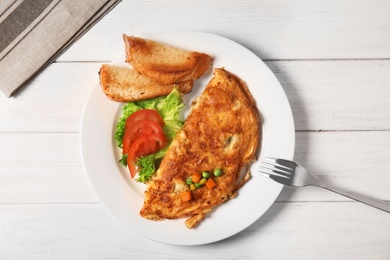 Photo of Omelet with vegetables on plate served for breakfast, top view