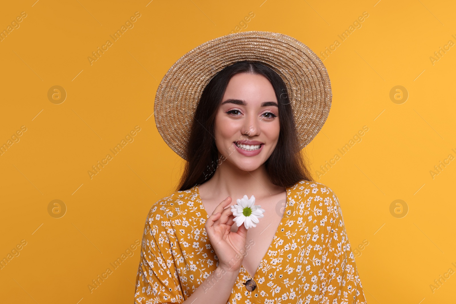 Photo of Beautiful woman with spring flower in hand on yellow background