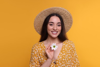 Beautiful woman with spring flower in hand on yellow background