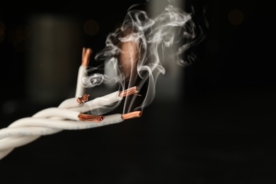 Image of Wiring with smoke on dark background, closeup