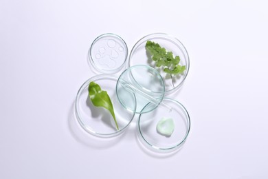 Photo of Organic cosmetic product, natural ingredient and laboratory glassware on white background, top view