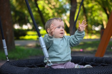 Photo of Portrait of cute little boy on swing in park