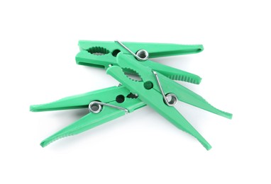 Photo of Bright green plastic clothespins on white background