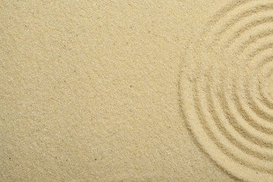 Photo of Zen rock garden. Circle pattern on beige sand, top view