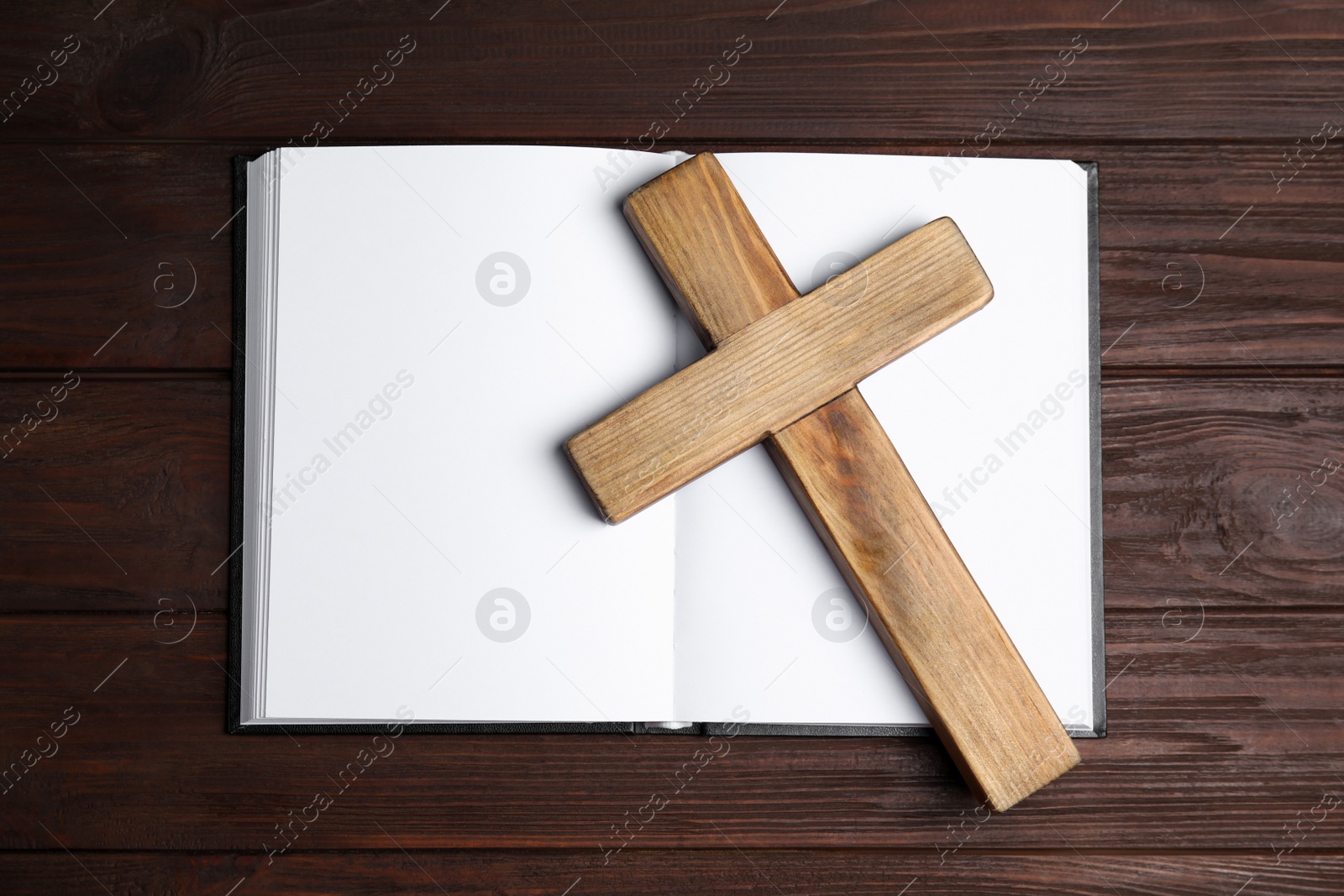 Photo of Christian cross and Bible on wooden background, top view. Religion concept