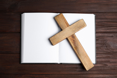 Christian cross and Bible on wooden background, top view. Religion concept