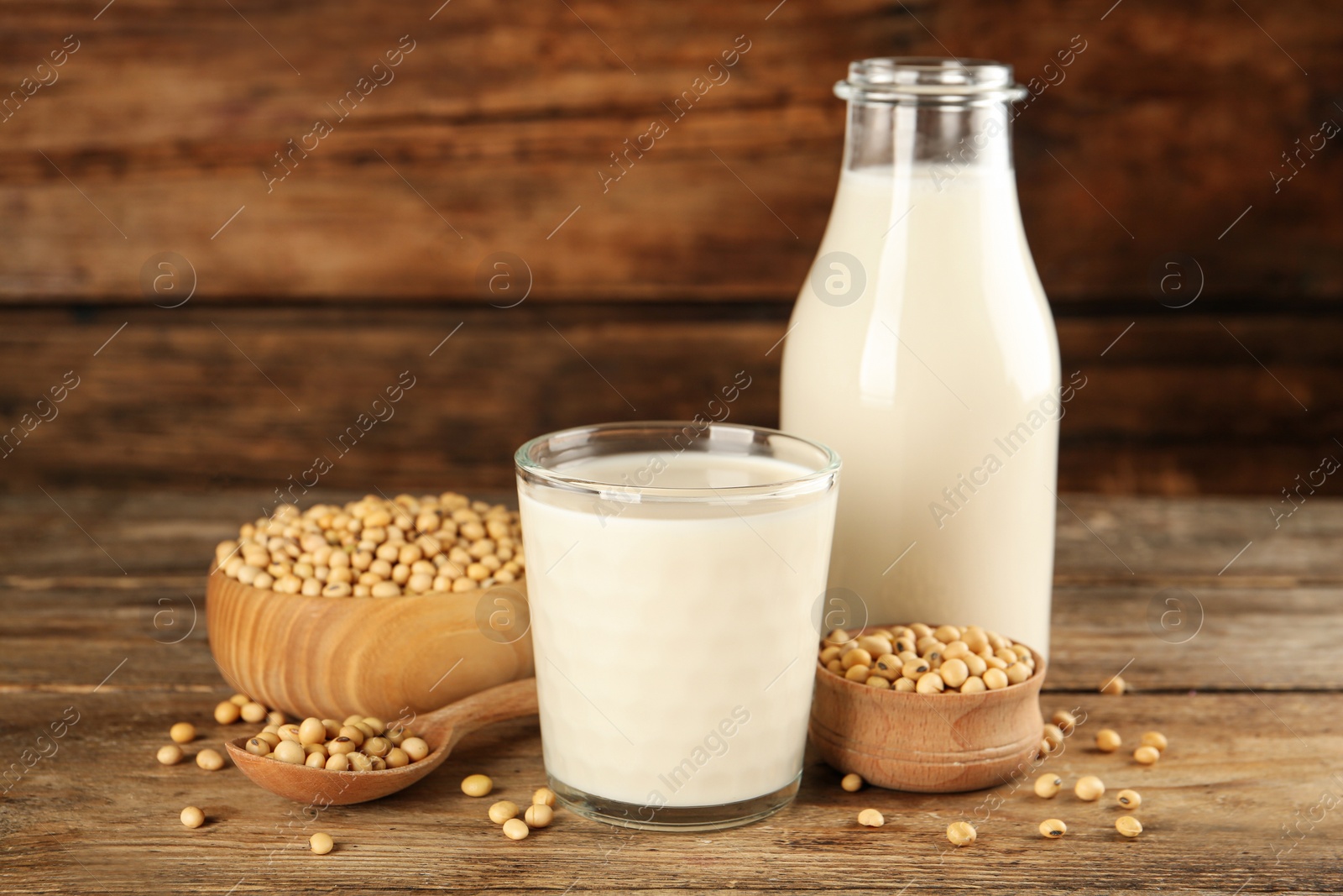 Photo of Fresh soy milk and grains on wooden table