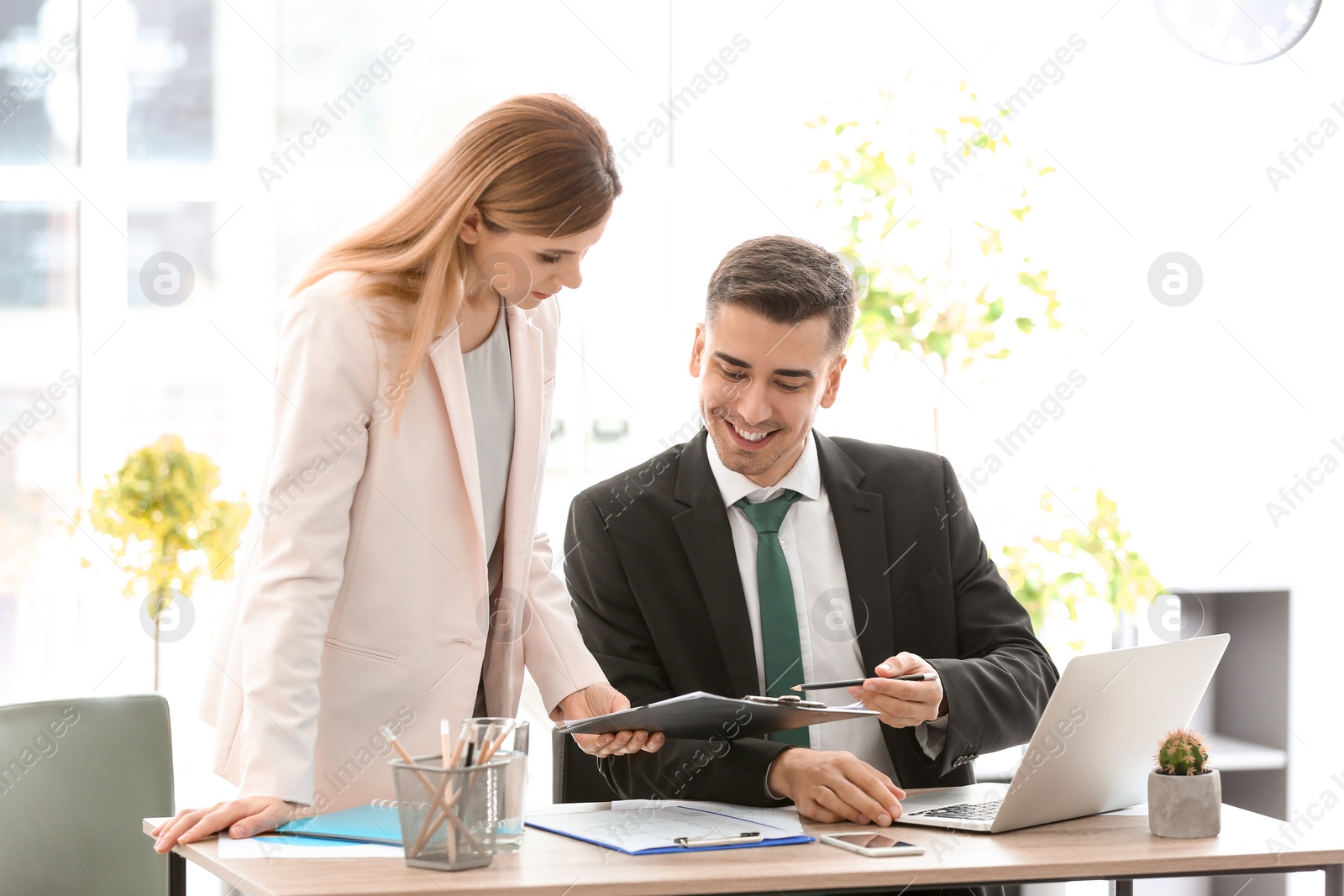 Photo of Young consultant working with client in office