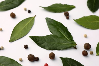 Aromatic bay leaves and spices on white background