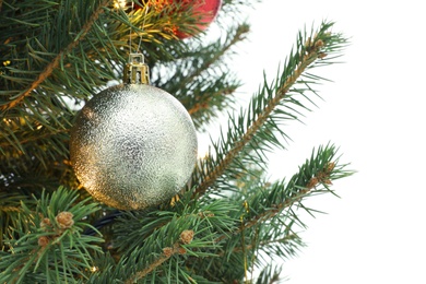 Photo of Christmas tree with beautiful golden bauble on white background, closeup