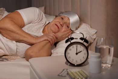 Elderly woman suffering from insomnia in bed at home