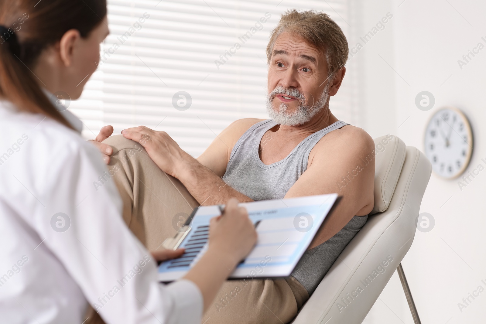 Photo of Doctor filling patient's medical card in clinic