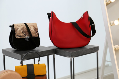 Photo of Stylish woman's bags on stands in boutique