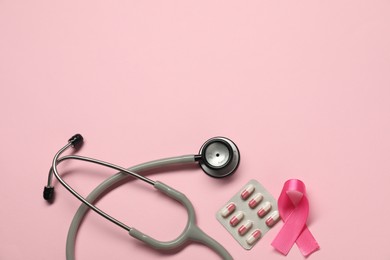 Photo of Breast cancer awareness. Pink ribbon, stethoscope and pills on color background, flat lay. Space for text