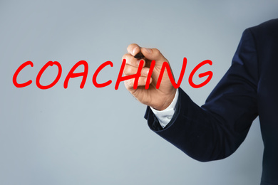 Image of Business trainer writing word Coaching on virtual screen, closeup