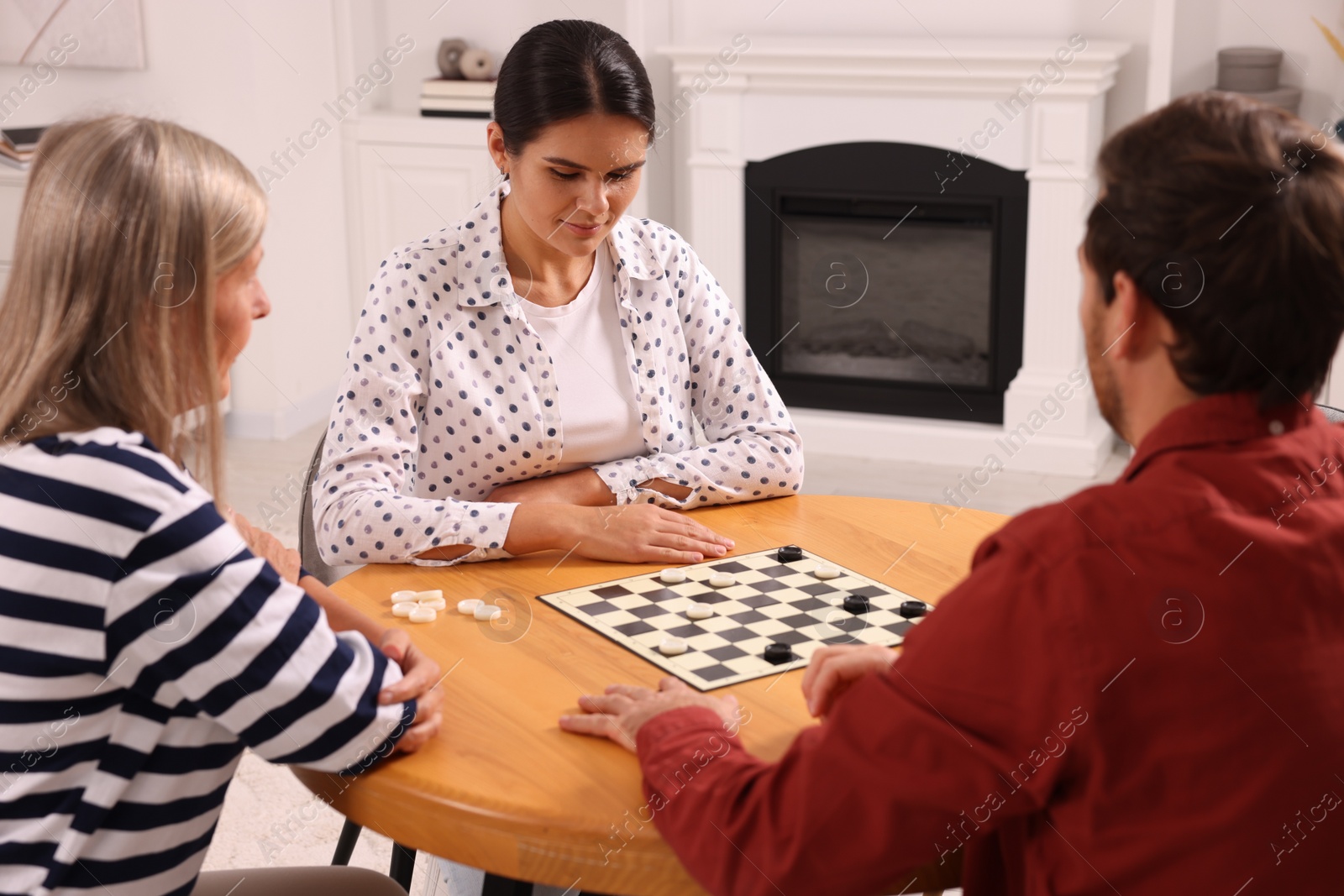 Photo of Family playing checkers at coffee table in room