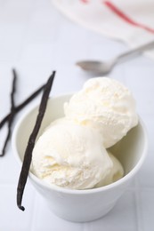Photo of Delicious ice cream and vanilla pod on white table, closeup