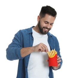 Young man with French fries on white background