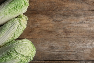 Photo of Fresh raw Chinese cabbages on wooden background, flat lay. Space for text