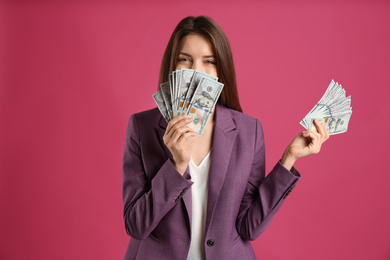 Photo of Young woman with cash money on pink background