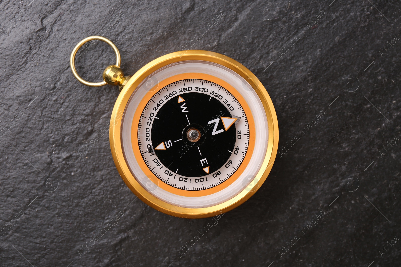 Photo of Compass on black textured background, top view. Navigation equipment