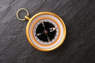 Photo of Compass on black textured background, top view. Navigation equipment